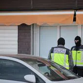 Dos policías nacionales custodian la puerta de uno de los edificios registrados en mayo de 2023