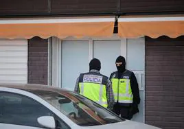 Dos policías nacionales custodian la puerta de uno de los edificios registrados en mayo de 2023