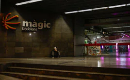Una persona sentada en una entrada del centro comercial Màgic Badalona