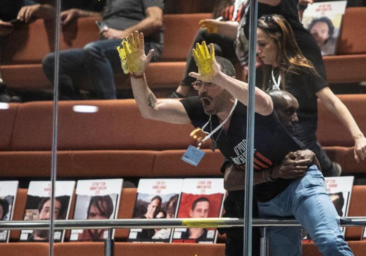 Un familiar de los rehenes muestra sus manos pintadas de amarillo en el Parlamento.