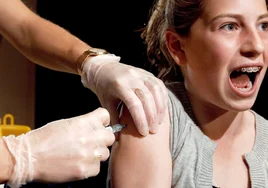 Una adolescente recibe la dosis de una vacuna.