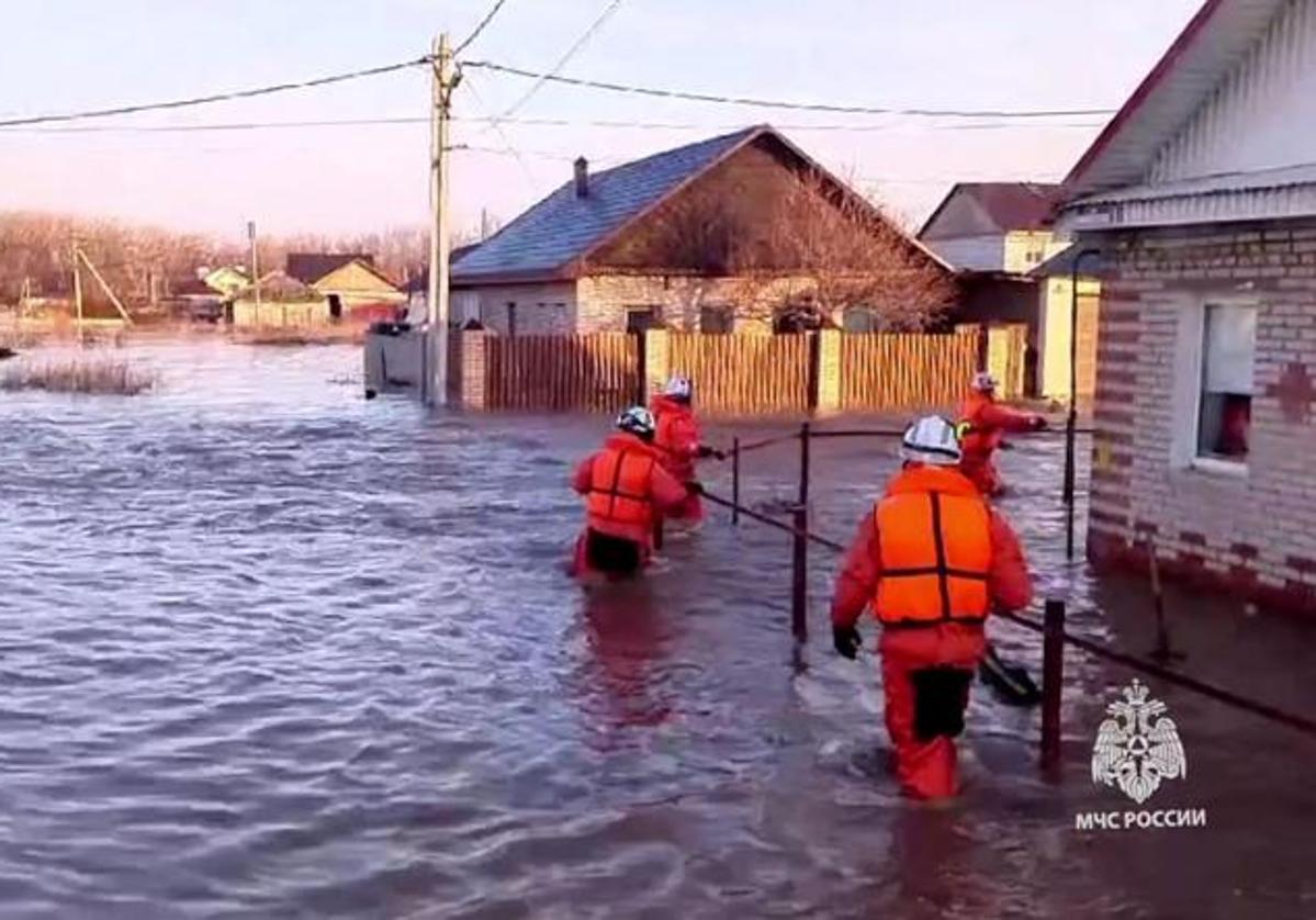 Un grupo de rescatistas camina por una calle inundada de la ciudad de Orsk, en la región de los Urales.