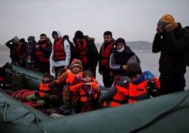 Un grupo de migrantes, entre ellos varios niños, se dispone a embarcar en una lancha para entrar en territorio europeo.