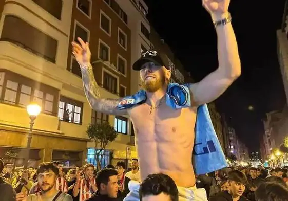 Muniain, a hombros de un aficionado, durante la espontánea celebración anoche en Bilbao
