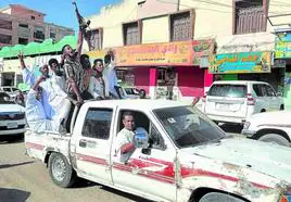 Sudaneses cantan consignas mientras conducen por una calle para expresar su apoyo al ejército en la ciudad de Gadaref, en el Sudán devastado por la guerra.