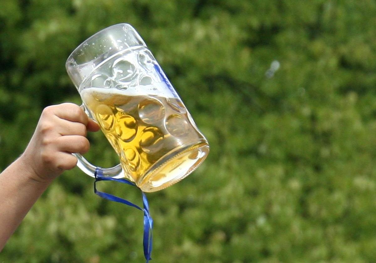 Un hombre brinda con una jarra de cerveza.
