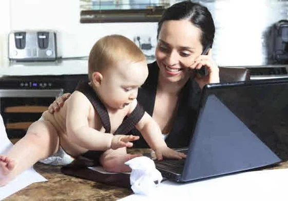 Mujer con su bebé y su ordenador.