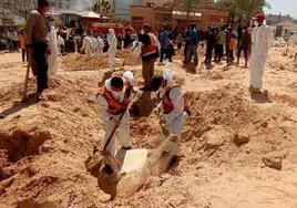 Los equipos de rescate desentierran cadáveres en una fosa común del hospital Naser de Jan Yuni.