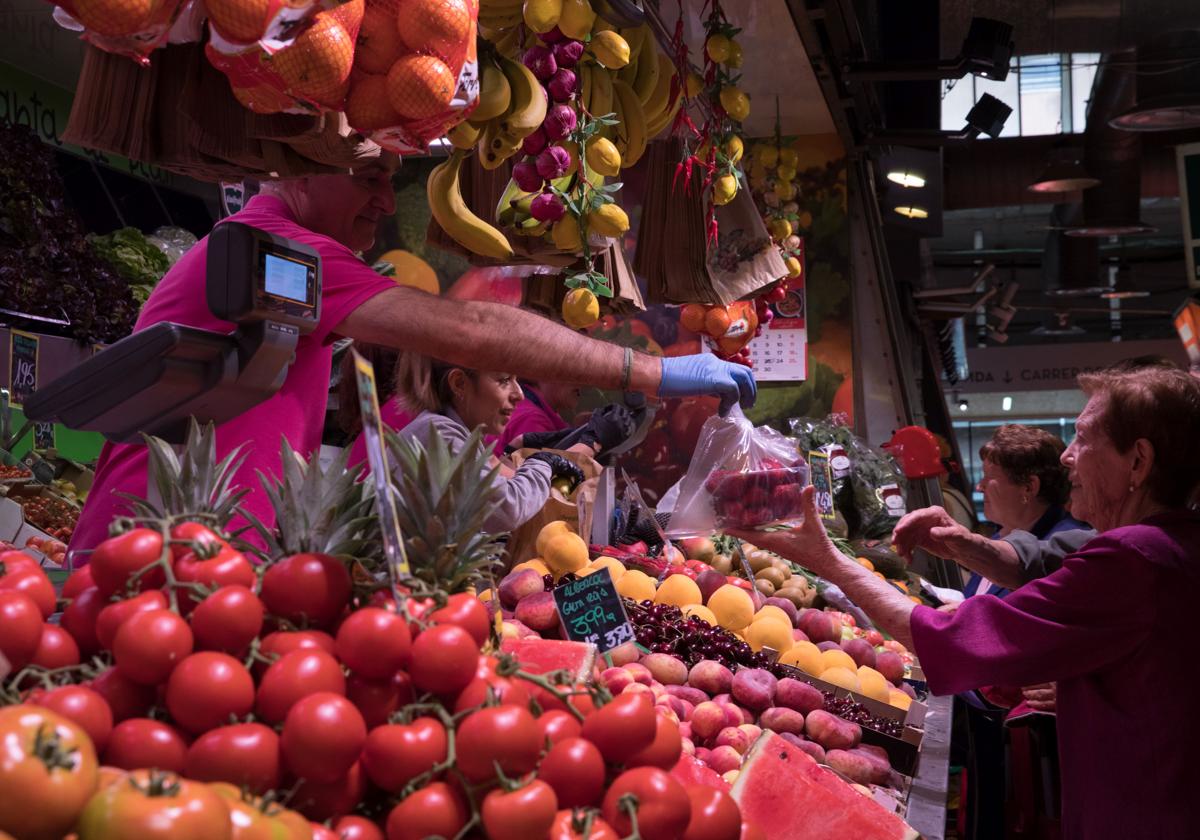 Varios ciudadanos compran en una frutería.