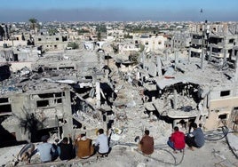 Un grupo de palestinos observa las casas destruidas por los ataques israelíes durante el conflicto, en el campo de refugiados de Jan Younis.