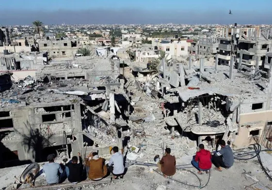 Un grupo de palestinos observa las casas destruidas por los ataques israelíes durante el conflicto, en el campo de refugiados de Jan Younis.