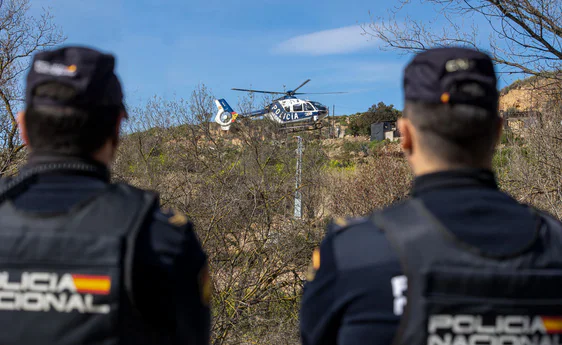 Dos agentes de la Policía Nacional observan el vuelo de un helicóptero