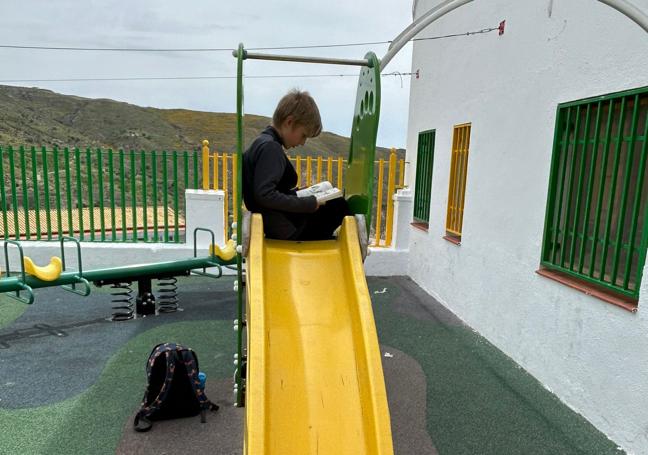 Un niño lee un libro tras cogerlo de la cabina.