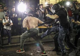 La Policía antidisturbios arremete contra un manifestante frente al Parlamento en Tiflis.