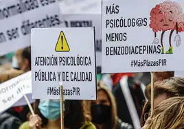 Varias personas sostienen diferentes pancartas en una marcha con motivo del Día Mundial de la Salud Mental.