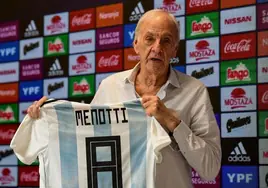 César Luis Menotti, sosteniendo una camiseta de la selección argentina con su nombre.