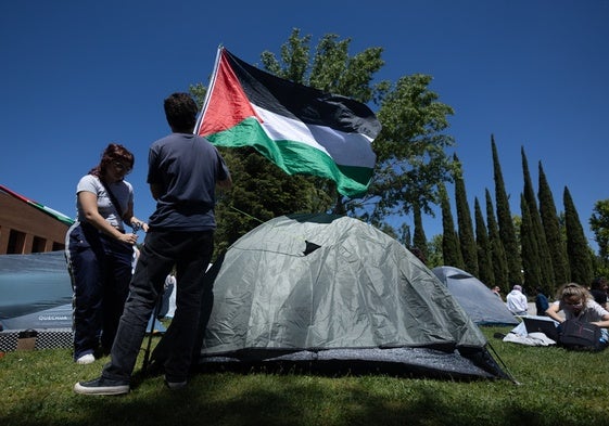 Universitarios madrileños montan una tienda de campaña con la bandera palestina.