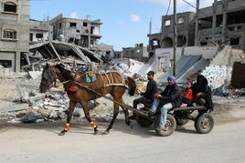 Una familia deja la periferia de Rafah con lo puesto, en un carro tirado por un caballo, ante la amenaza de los bombardeos.