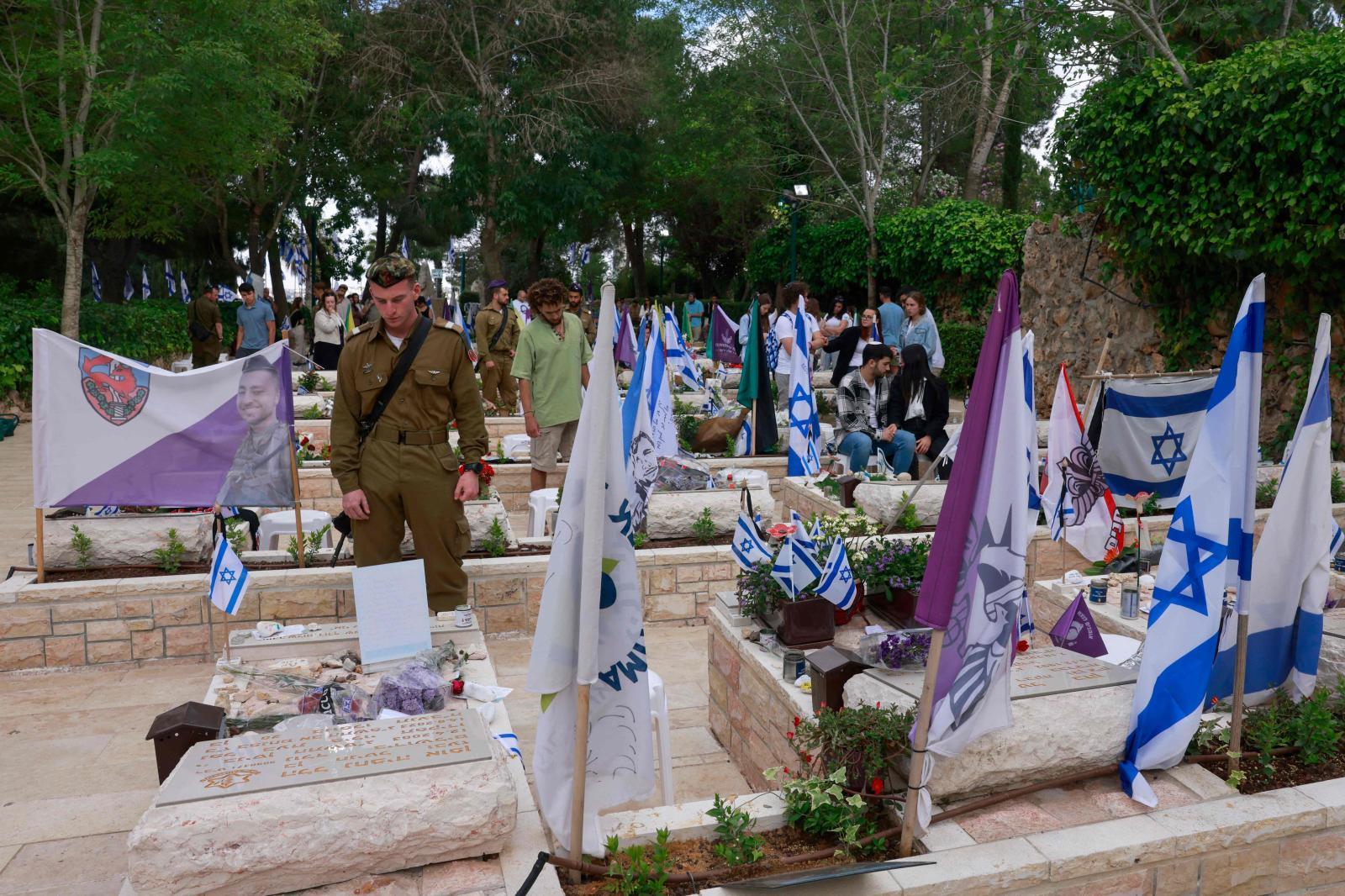 Un militar reza ante las tumbas de sus compañeros en el monte Herzl.