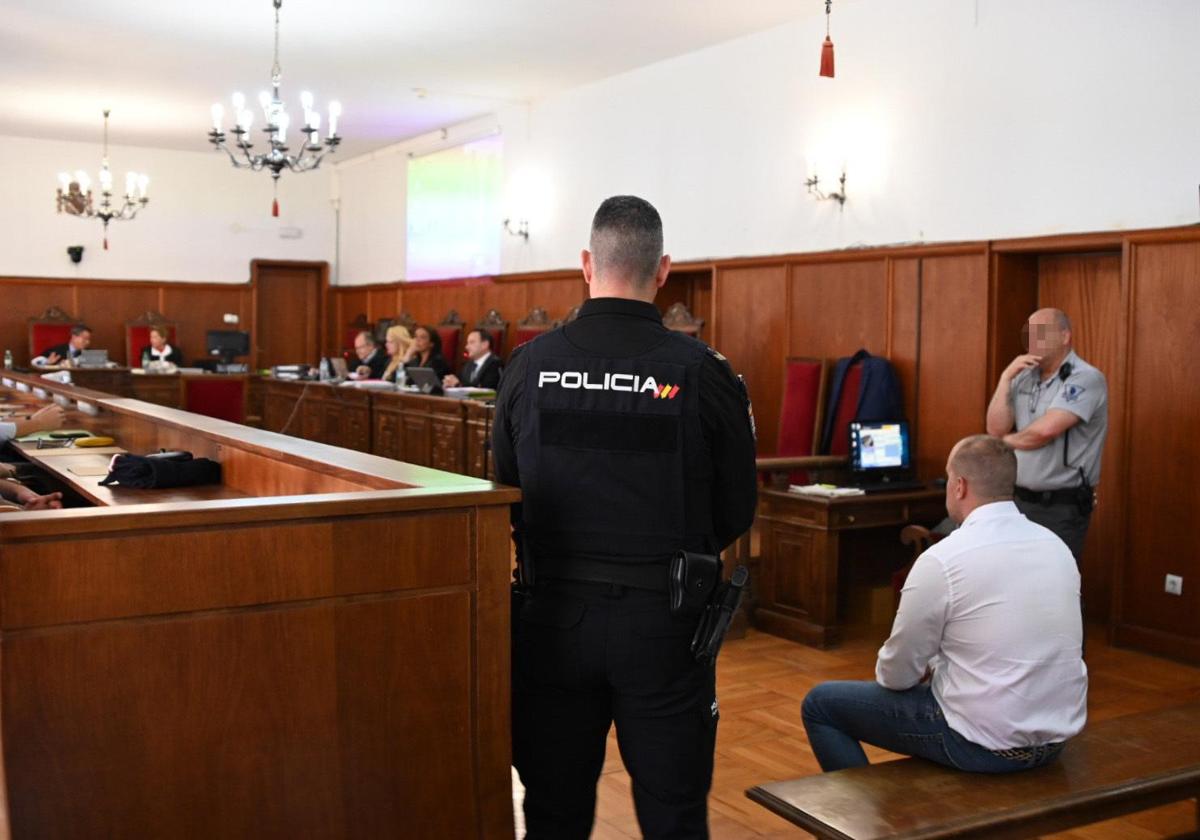 Un agente de Policía Nacional junto al acusado de la muerte de Manuela Chavero, Eugenio Delgado, durante el juicio en la Audiencia Provincial de Badajoz.