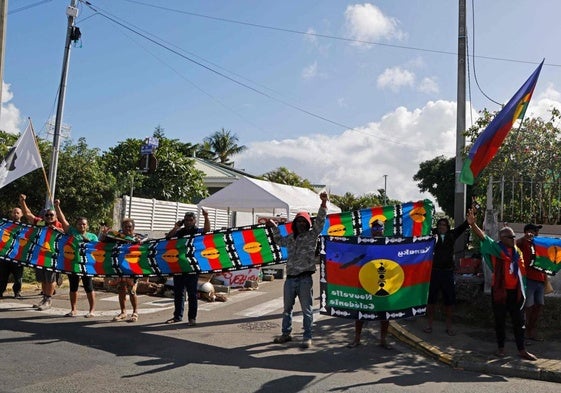 Residentes se manifiestan al paso de la caravana del presidente francés, Emmanuel Macron, por Noumea, la capital de Nueva Caledonia.