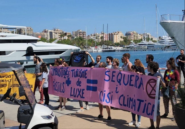 Los jóvenes activistas despliegan sus pancartas en la marina de Barcelona.