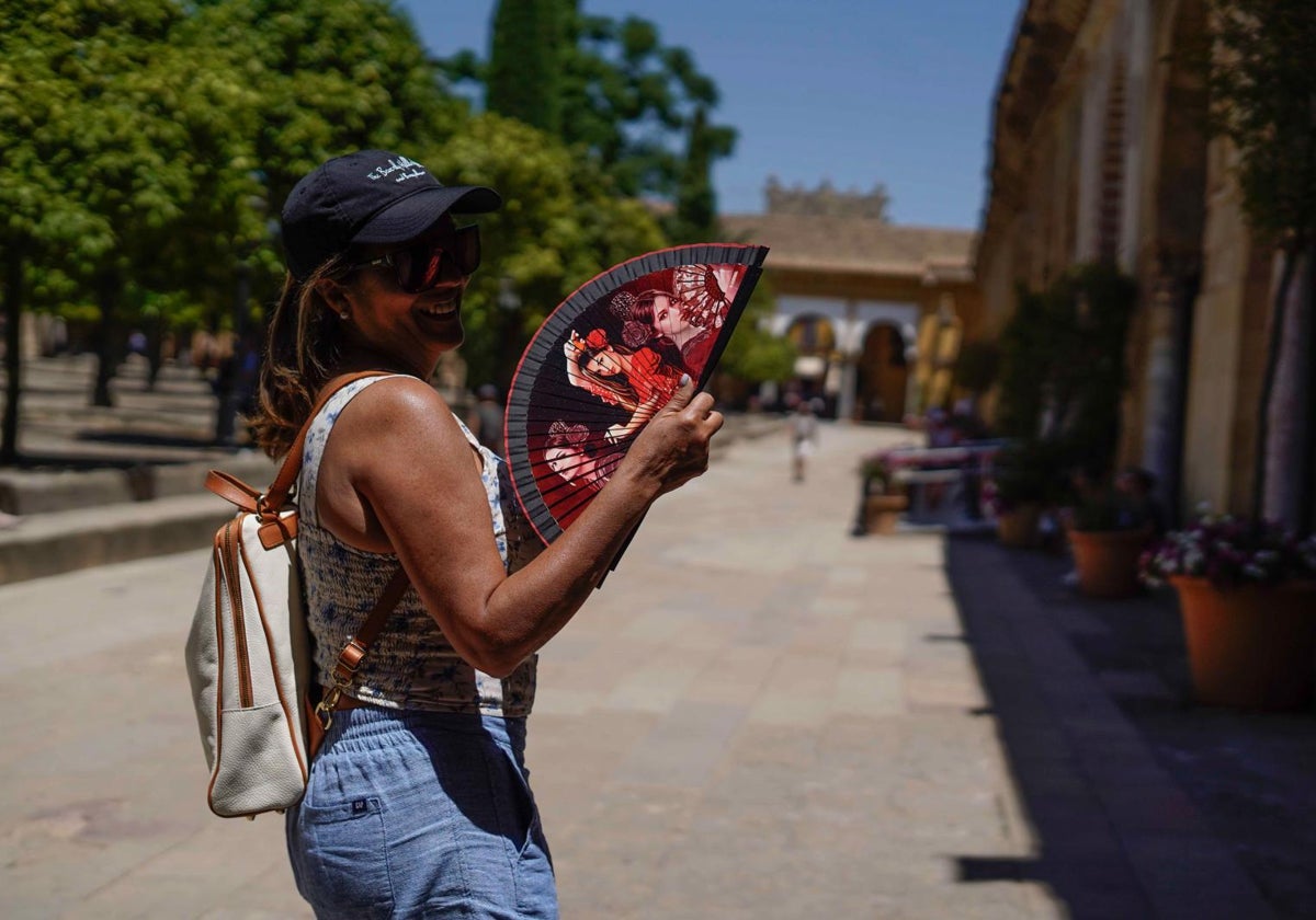 Una mujer se abanica en el Patio de los Naranjos de Córdoba, donde el termómetro este jueves se acerca a los 40 grados.