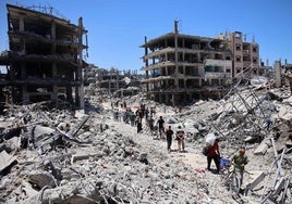 Un grupo de palestinos cargan algunas pertenencias al abandonar el campo de refugiados de Yabalia, en el norte de la Franja de Gaza.