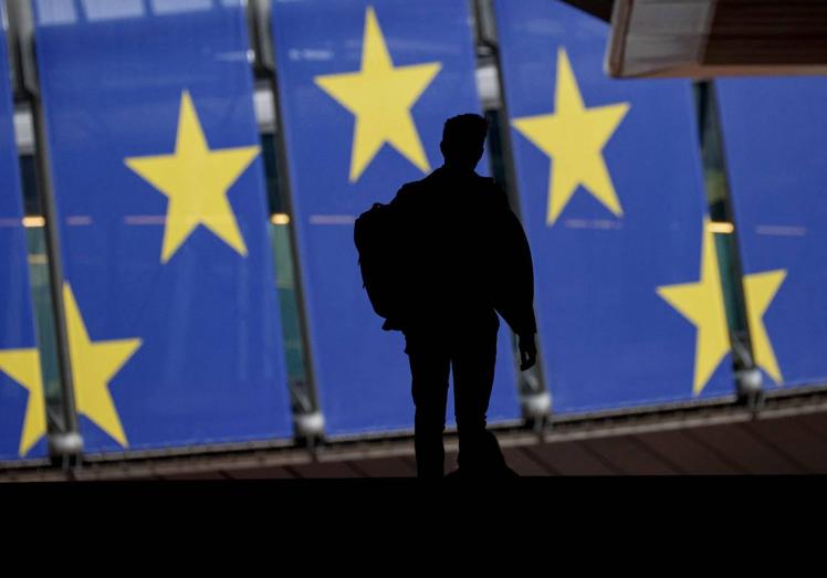 Un hombre camina frente al edificio del Parlamento Europeo en Bruselas.