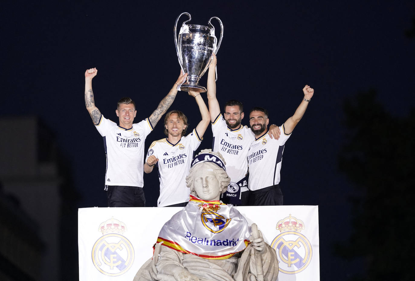 Los cuatro capitanes del Real Madrid -Kroos, Modric, Nacho y Carvajal- sostienen la 'orejona' junto a la estatua de la diosa Cibeles.