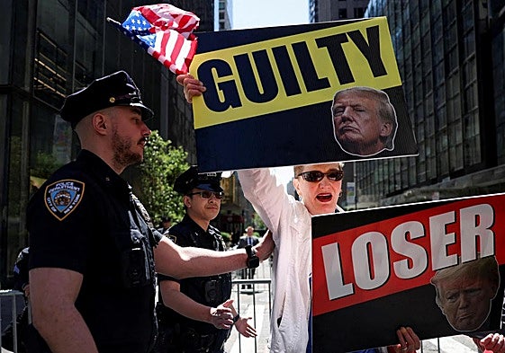 Un manifestante anti-Trump sostiene pancartas frente a la Torre Trump, en Nueva York.