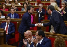 El nuevo presidente del Parlament, Josep Rull, recibe el saludo del jefe en funciones del Govern, Pere Aragonès, con el socialista Illa sentado en su escaño.