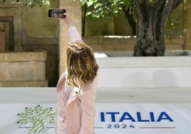 La primera ministra de Italia, Giorgia Meloni, se toma una selfie mientras espera la llegada del presidente estadounidense, Joe Biden.