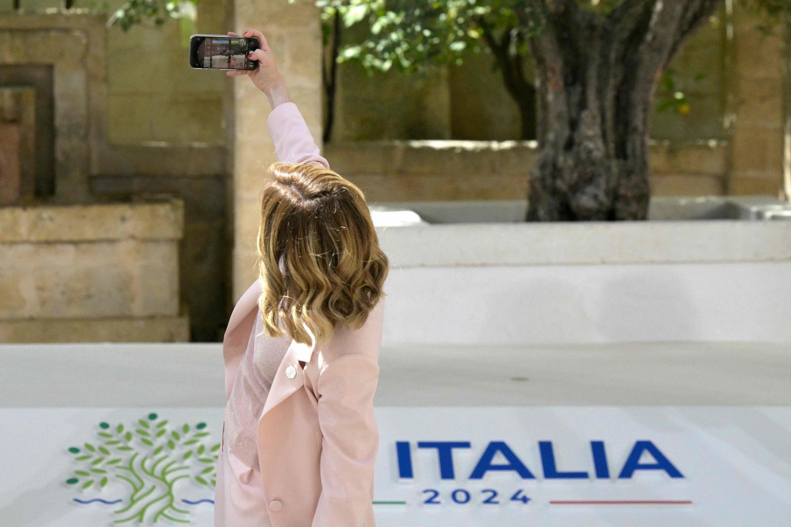 La primera ministra de Italia, Giorgia Meloni, se toma una selfie mientras espera la llegada del presidente estadounidense, Joe Biden.