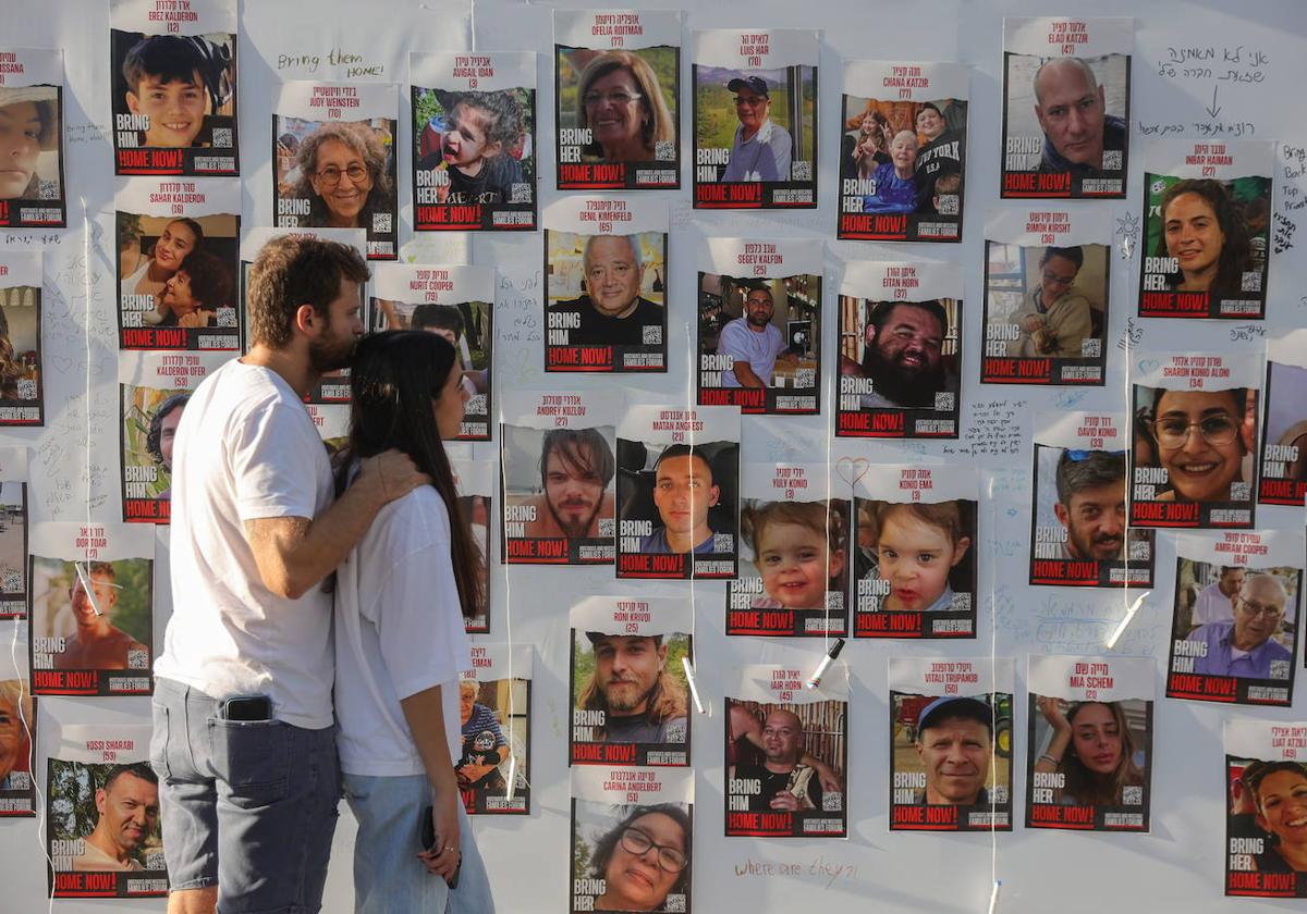 Una pareja observa fotografías de las víctimas del 7-O.