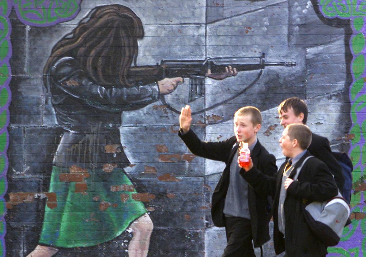 Imagen de archivo de unos jóvenes junto a un mural dedicado a las terroristas del IRA.