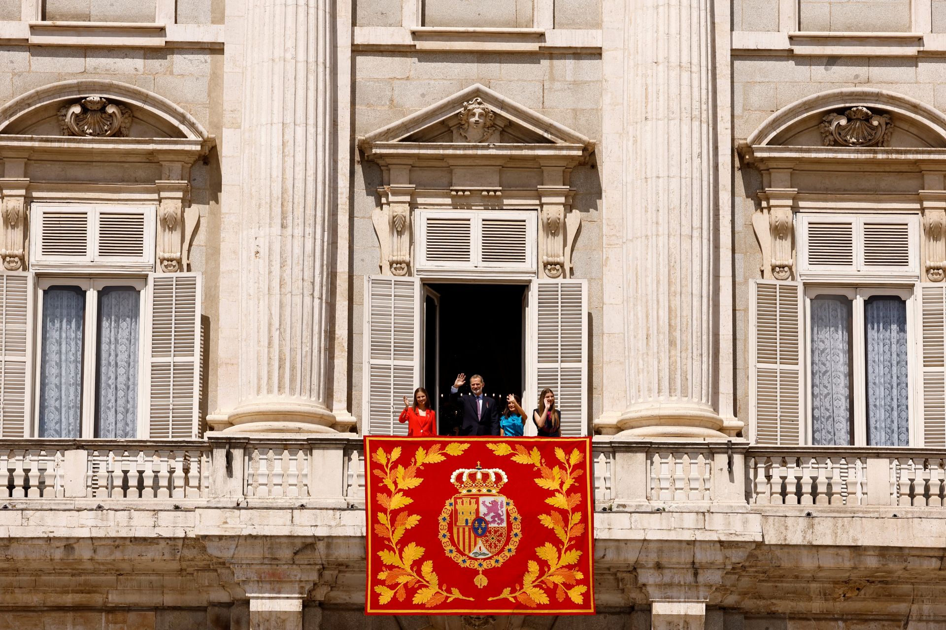 El rey español Felipe, la reina Letizia y sus hijas, la princesa Leonor y la infanta Sofía, saludan desde un balcón después de asistir al relevo de la Guardia Real