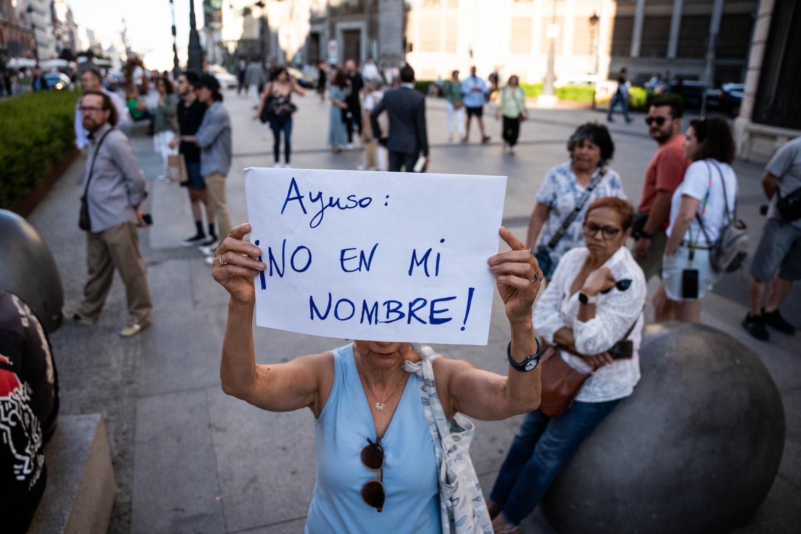 Una manifestante muestra una pancarta contra Javier Milei.