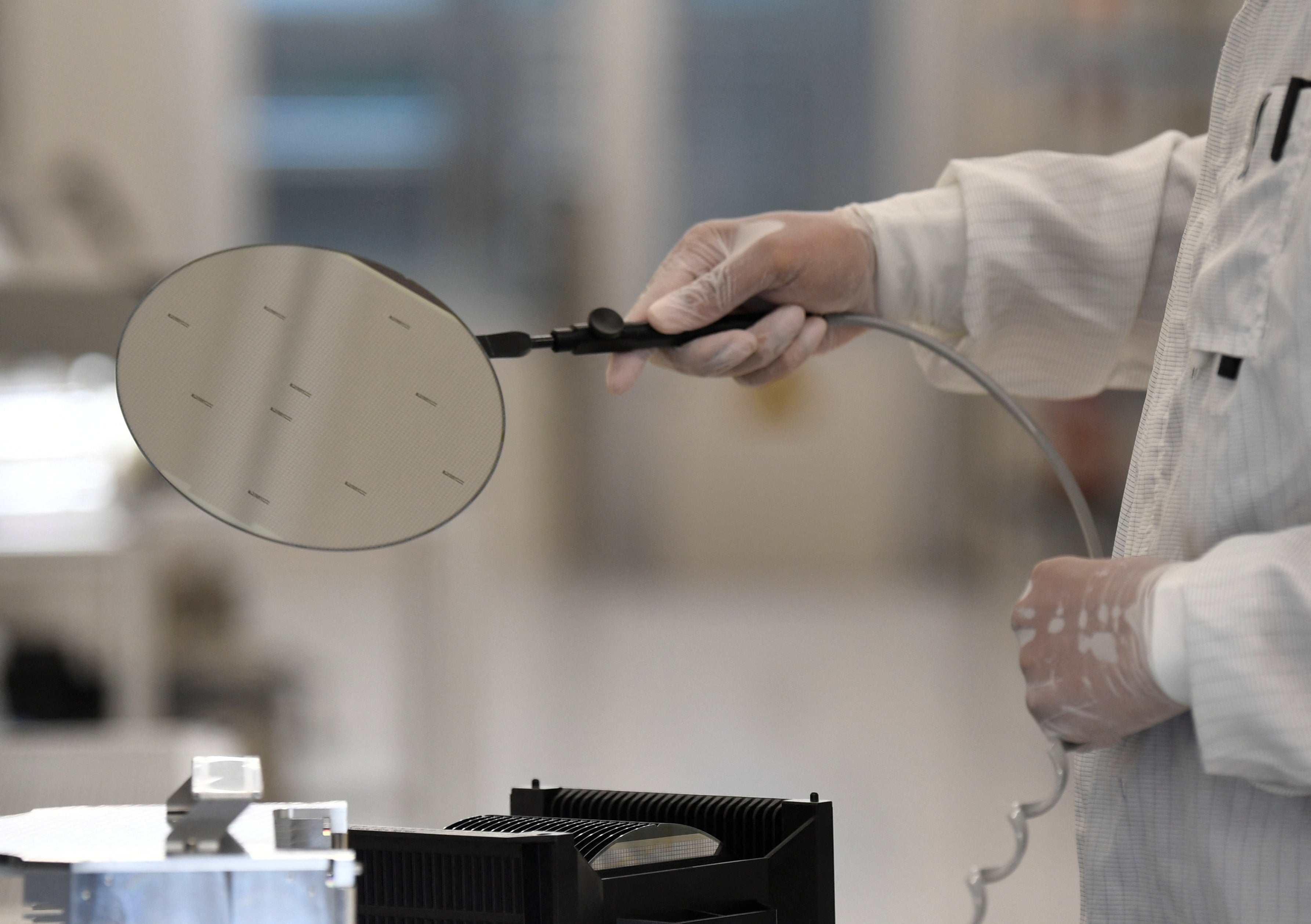 Un trabajador, en una imagen de archivo, manipula una oblea de semiconductores.