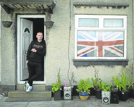 Un vecino de Keighley, en el noroeste de Inglaterra, fuma en la puerta de su hogar.