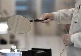 Un trabajador, en una imagen de archivo, manipula una oblea de semiconductores.