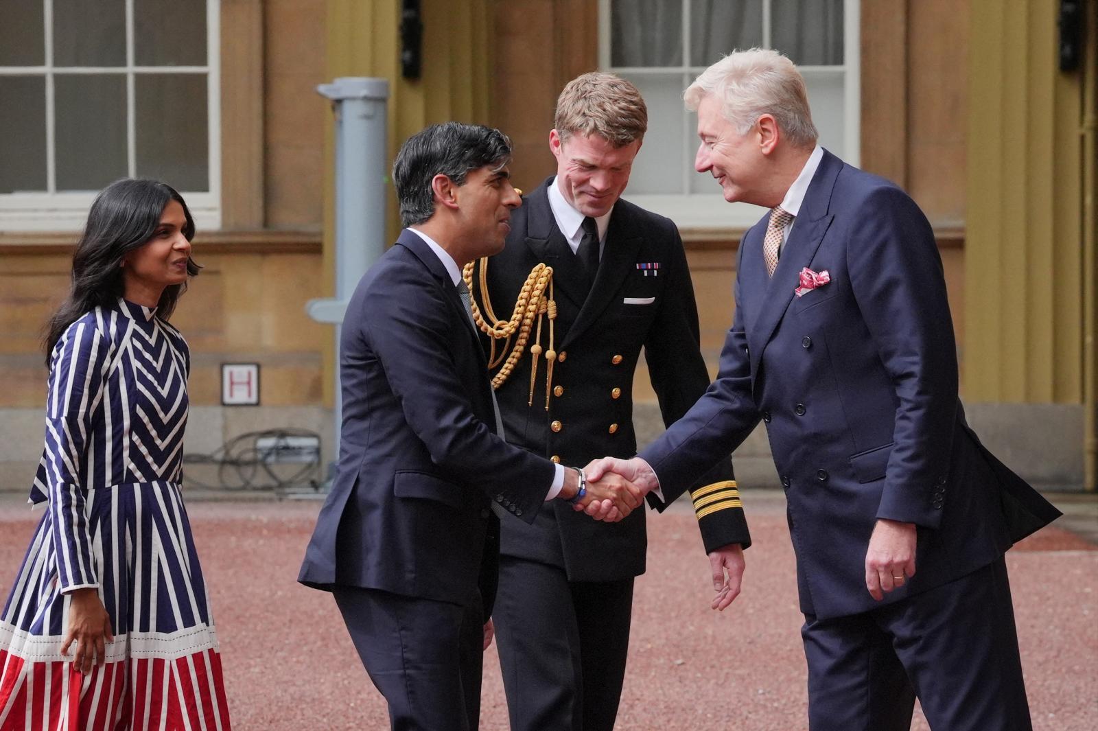 El secretario particular de Carlos III, sir Clive Alderton, recibe a Sunak en el Palacio de Buckingham antes de su audiencia con el rey.