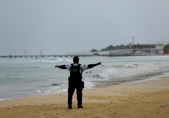 Un policía mexicano realiza labores de inspección en Playa del Carmen antes la llegada del huracán 'Beryl'