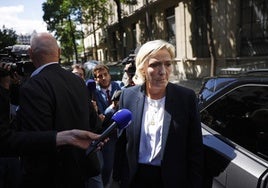 La líder ultraderechista Marine Le Pen es abordada por la prensa frente a la sede de su partido en París.