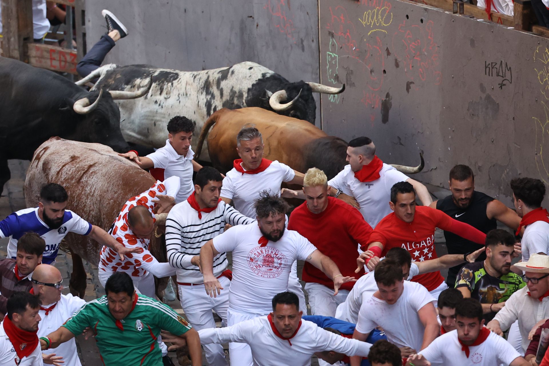 Varios mozos son perseguidos en el tramo inicial de la calle Estafeta desde la curva de Mercaderes durante el segundo encierro de los Sanfermines protagonizados por la ganadería de los Herederos de D. José Cebada Gago, de Medina Sidonia (Cádiz).