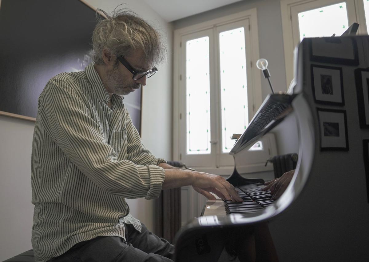 Imagen secundaria 1 - Rhodes, durante la entrevista, tocando el piano y tomando una fotografía.