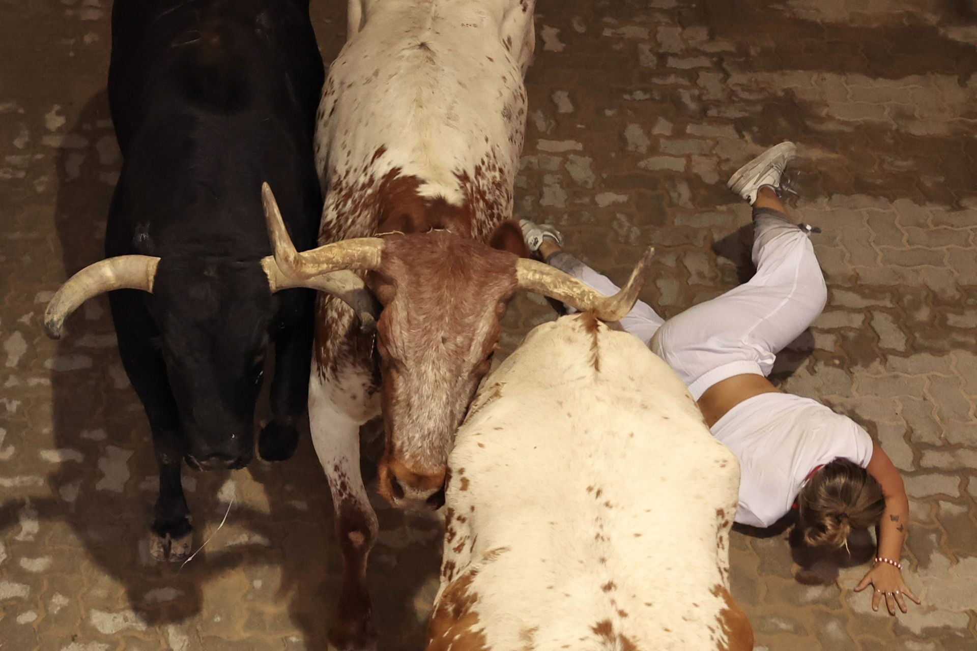 Un mozo cae al paso de los toros de Victoriano del Río en el callejón de acceso a la plaza de toros. 