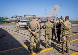 La primera ministra danesa, Mette Frederiksen, habla con un grupo de militares frente a un caza F-16 en la base aérea Fighter Wing Skrydstrup,