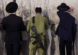 Un soldado reza junto a ultraortodoxos en Jerusalén.