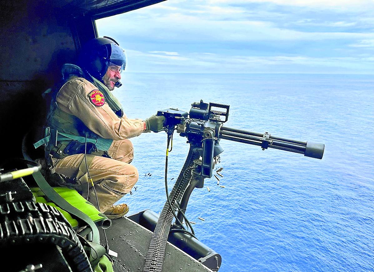 Un tripulante realiza un ejercicio de tiro desde el helicóptero.